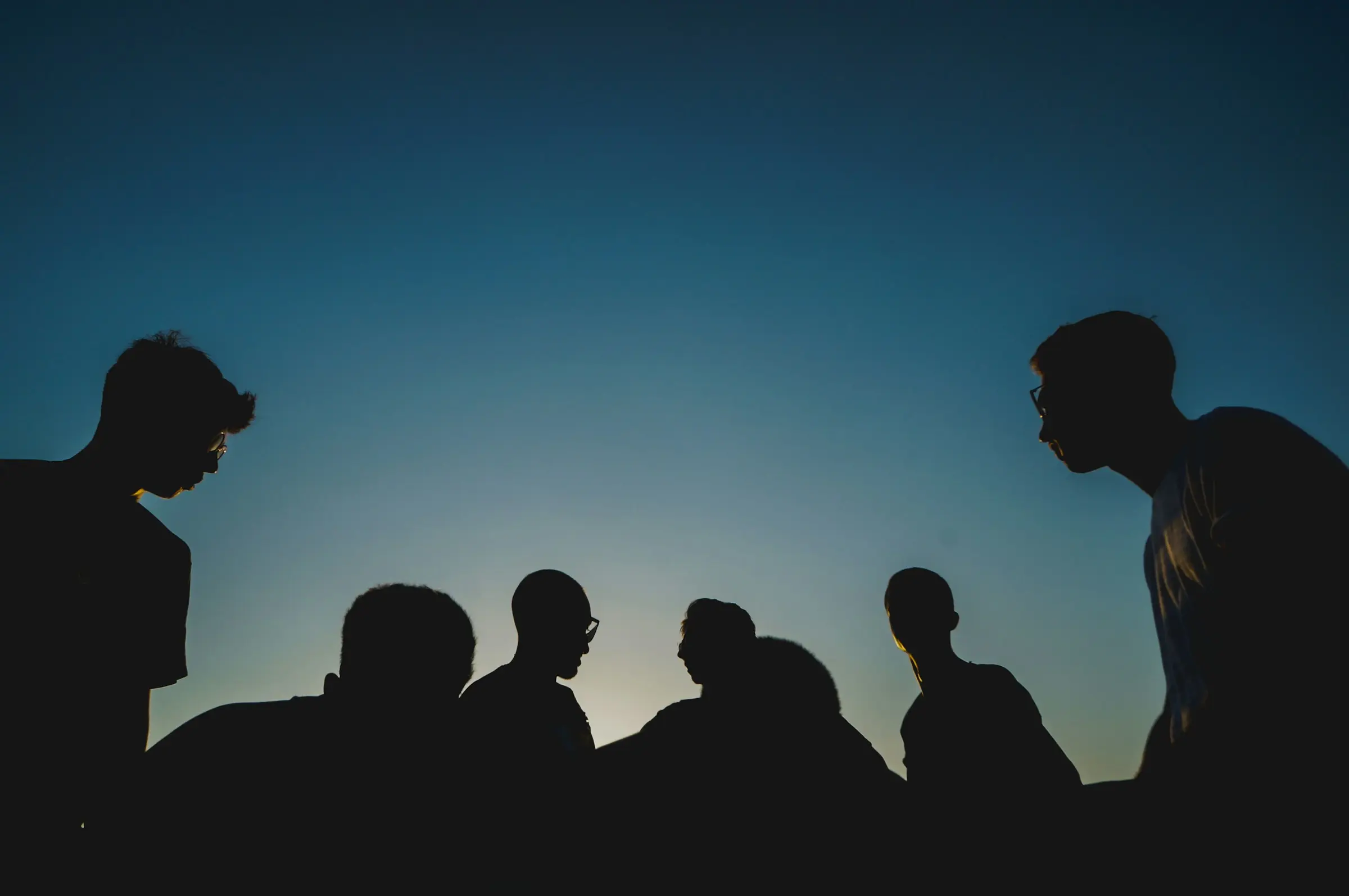 Group of people in silhouette against a blue sky