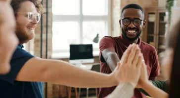 pexels-diva-plavalaguna-6146695 Two people giving a high five indoors.