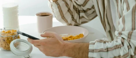 pexels-mart-production-8107172 Man eating breakfast at a table.