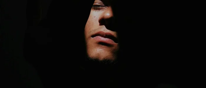 Person partially hidden in darkness.