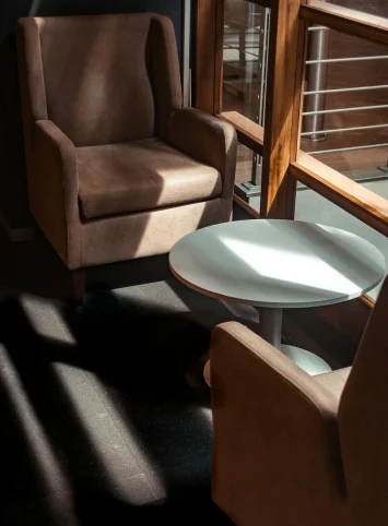 Chairі and small table in a sunlit room.