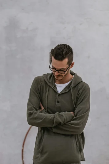 sincerely-media-Pp51_j1F-N8-unsplash Man standing with arms crossed, looking down